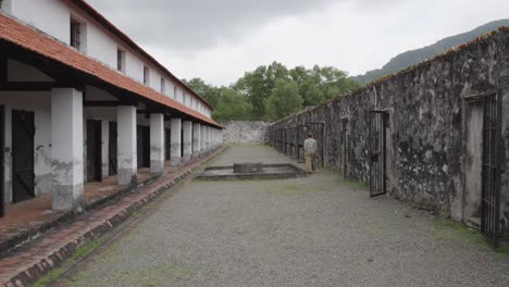 A-Tourist-Exploring-Inside-The-Oldest-Prison-In-Con-Dao-Island,-Ba-Ria-Vung-Tau,-Vietnam