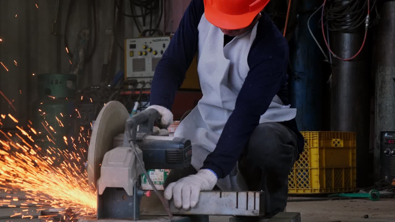 보호 안경과 건설 장갑을 입은 전문 남자들은 전기 강철 절단기 기계로 가정 작업장에서 일합니다. 금속을 절단하면 불꽃이 날아갑니다.