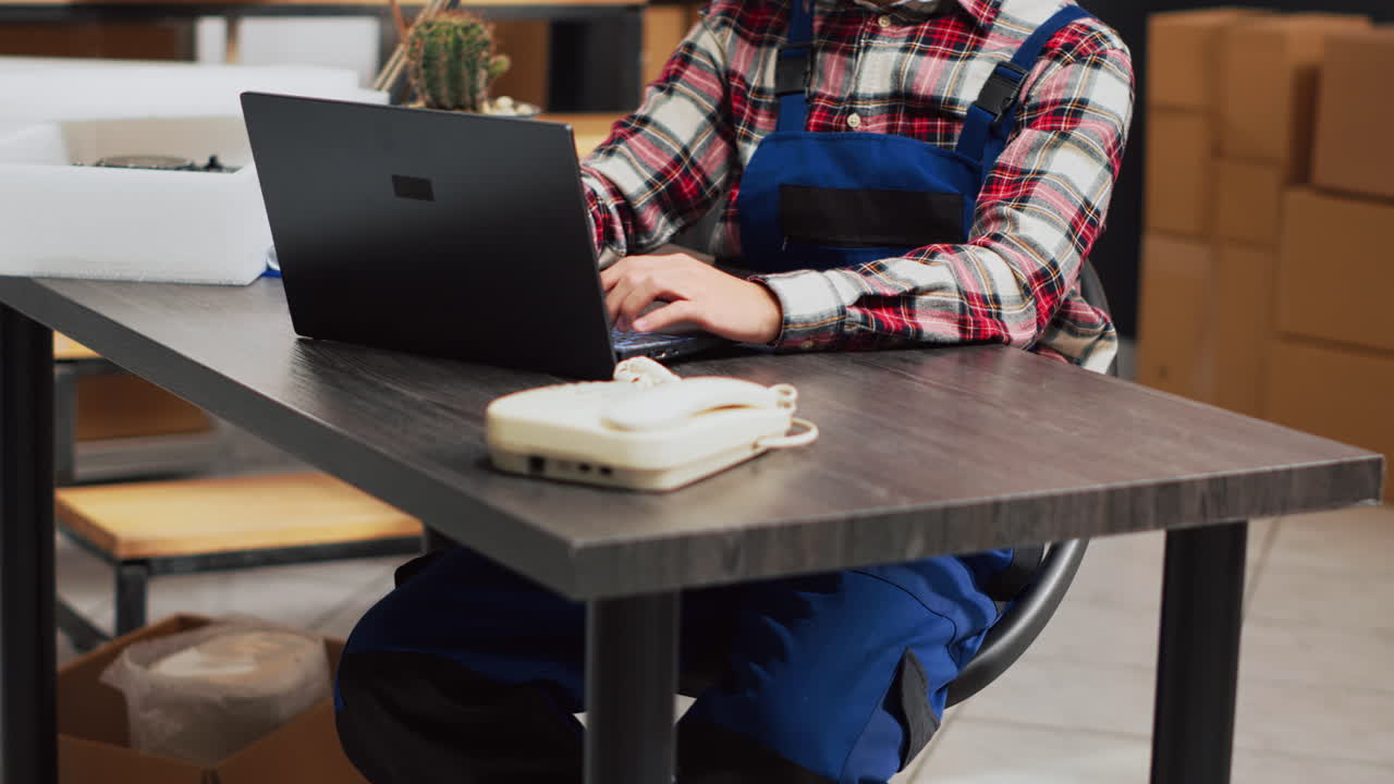 Funcionários com notebook e caixas de papelão no armazém
