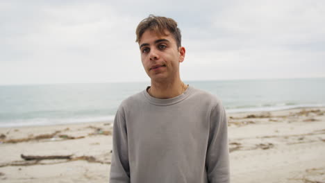 Boy Shrugs Hopefully While Talking To Friend At Beach Overcast Sky
