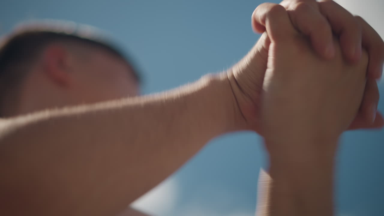 Joven extendiendo los brazos hacia el cielo bajo un sol brillante y cielos azules, adolescente mirando hacia arriba con las manos extendidas bajo la luz del sol radiante y amplios cielos azules