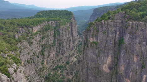 aerial view of a dramatic canyon with steep cliffs and lush forests