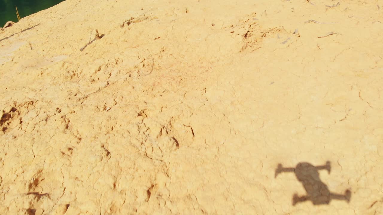 태국의 숲 옆 마른 강둑 위를 날고 있는 드론 - 낮은 공중