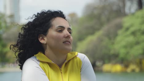 cerca de una joven morena en forma estirando los brazos después de un entrenamiento en el bosque de palermo