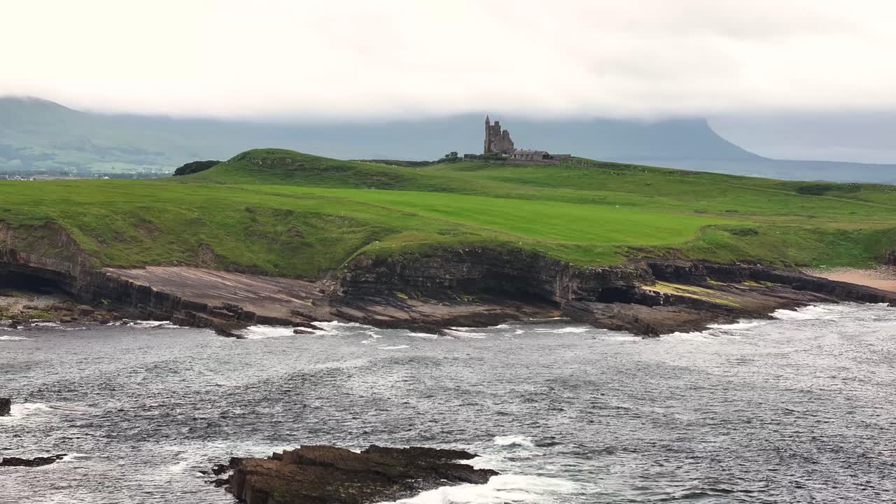 Rugged rocky coastal of Mullagmore with castle building and misty background. Ireland