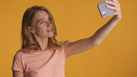 caucasian woman taking selfies on smartphone.