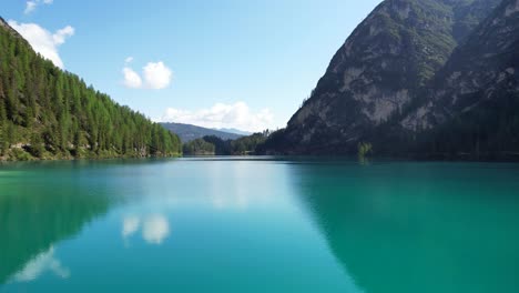 Aerial-shot-over-calm-turquoise-waters-of-Lake-Braies-in-Dolomiti-National-Park,-Italy