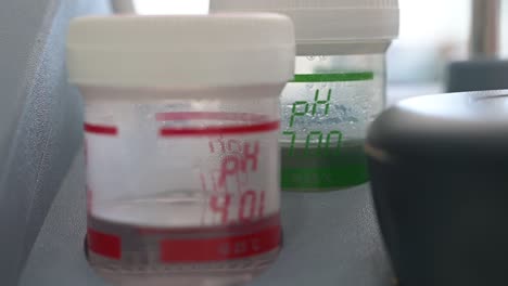 laboratory jars with liquid indicating the acid number in ph