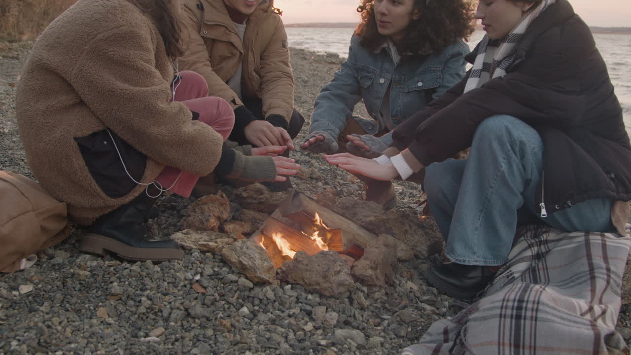 스마트폰에 빛나는 크리스마스 트리 타이핑 근처의 아늑한 방에 놀란 얼굴로 앉아 있는 쾌활한 아름다운 여성의 초상화를 닫습니다
