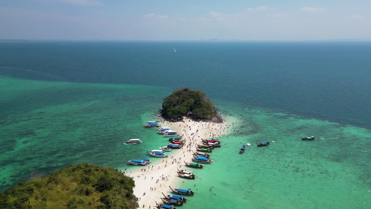 Aerial view of the famous Tub Islands in Krabi, Thailand, showing the narrow sandbar packed with tourists and boats surrounded by clear turquoise waters