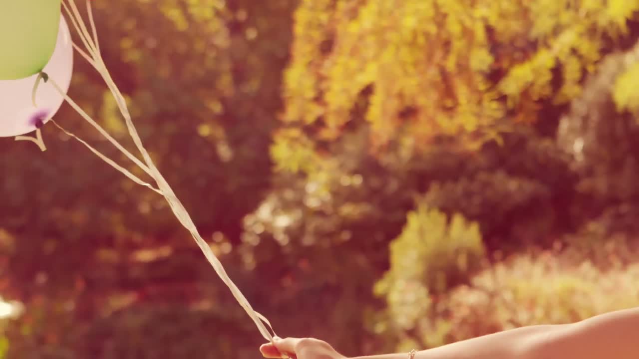 행복한 커플이 공원에서 포옹하고 풍선을 들고 있습니다.