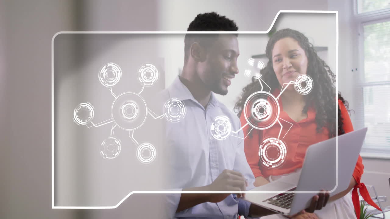 In office, colleagues discussing animation and digital network connections using laptop