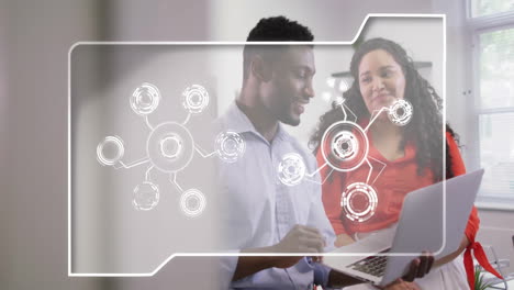 in office, colleagues discussing animation and digital network connections using laptop