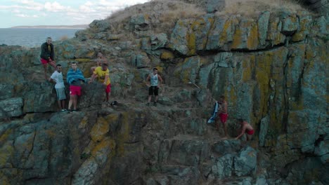 boys climb seashore cliff, prepare for jump in the water, bulgaria