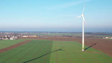 Wind-Turbines-And-Surrounding-Farm-Land-At-Daytime---aerial-drone-shot