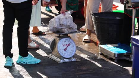 seafood being weighed at a bustling market