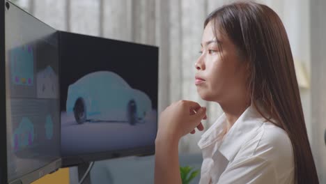 close up side view of asian female automotive designer thinking of idea while working on 3d model of ev car on the desktop computers in the studio