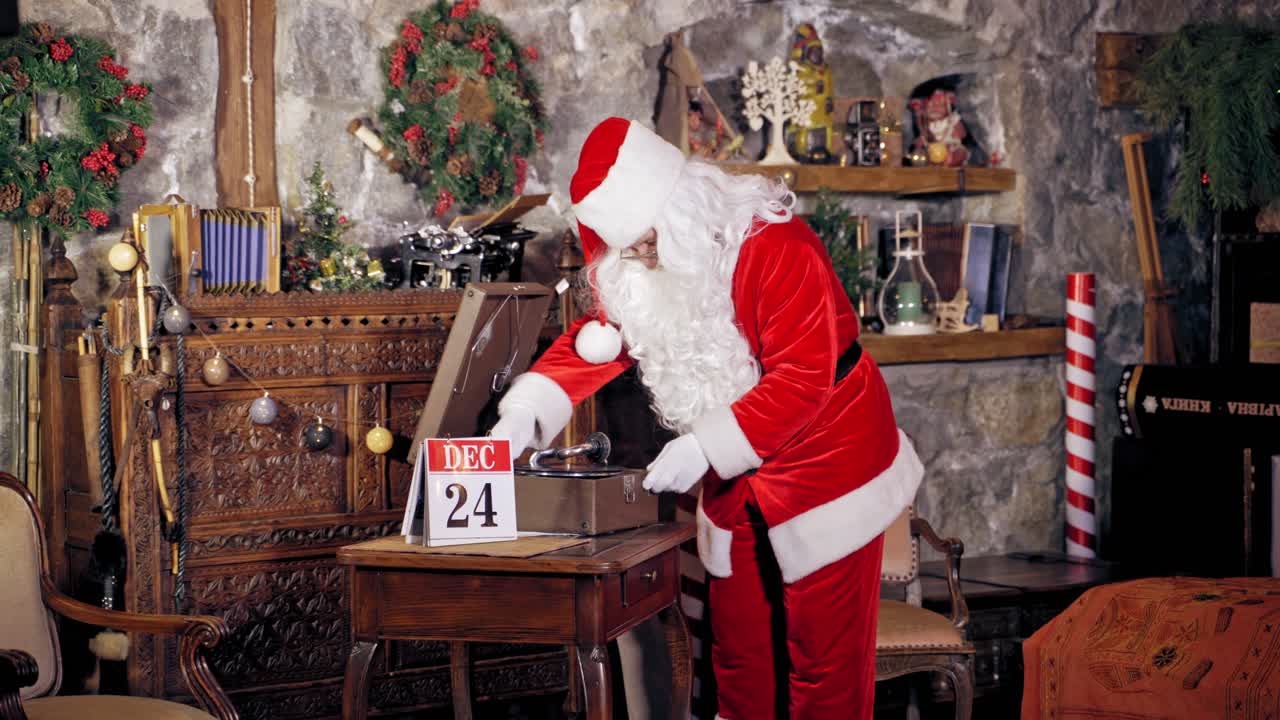 Santa Claus standing in specially decorated room, putting shellac or record on a gramophone or record player. Christmas spirit concept close up portrait. Christmas eve. New Year is coming