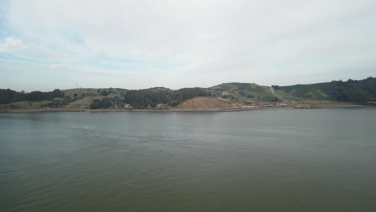 A dynamic aerial drone view of Point Molate Beach, revealing the blend of nature and history with scenic landscapes and remnants of old structures along the coast.