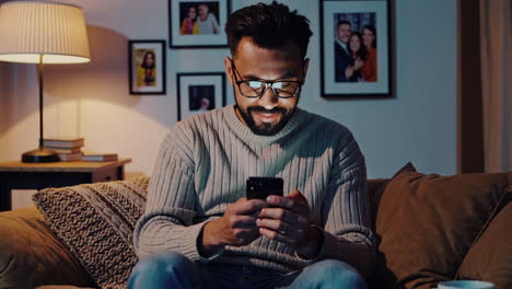man using his phone on the couch