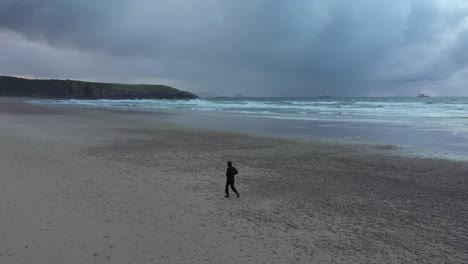 Rückansicht-Des-Mannes,-Der-Allein-Auf-Einem-Leeren-Einsamen-Strand-Spazieren-Geht