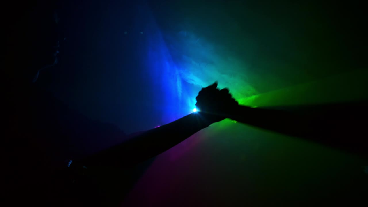 рукопожатие двух людей в темноте на фоне треугольника с лучами света.