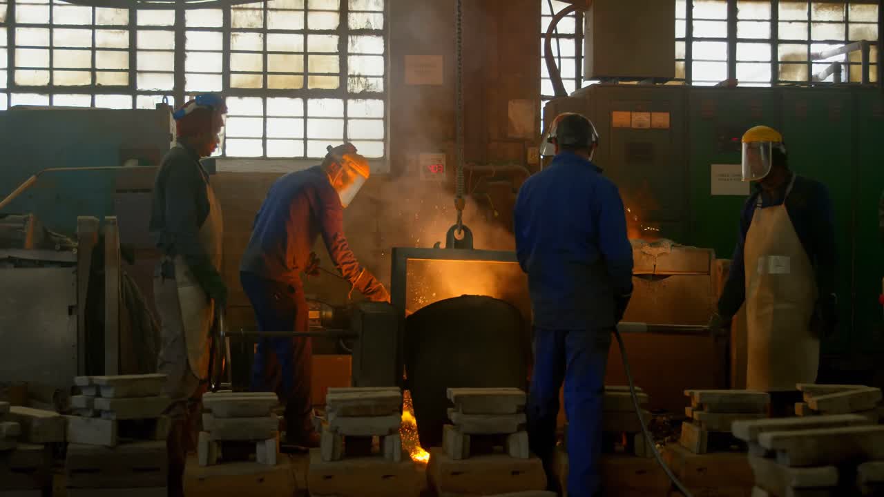 рабочие, плавлящие металл в литейной мастерской 4k