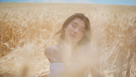 contemplative girl sitting field alone close up. romantic woman looking camera