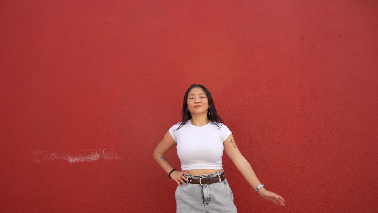 Woman in white t-shirt posing against red background