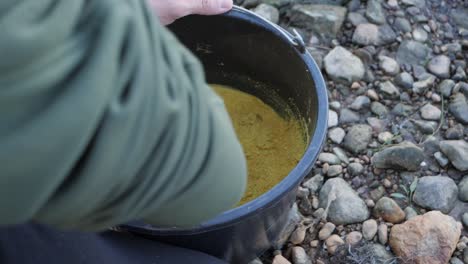 Man-mix-fishing-bream-bait-in-bucket,-slow-motion