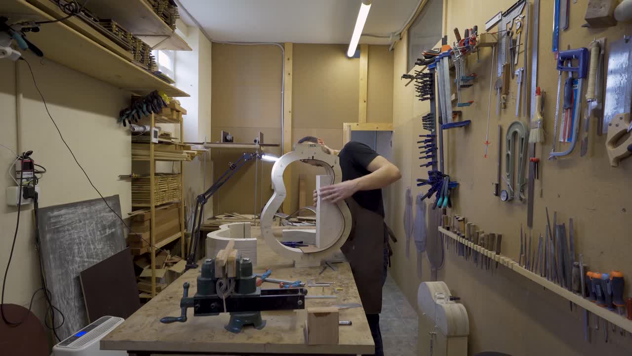 guitarrista construyendo una guitarra en la mesa en el taller