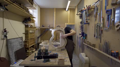 guitarrista construyendo una guitarra en la mesa en el taller