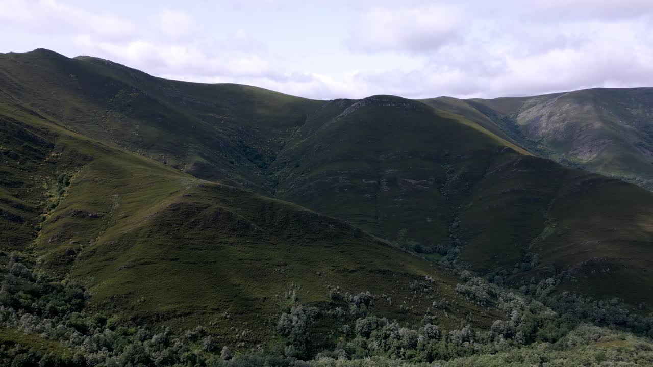 Riprese aeree con drone di una valle in un lussureggiante paesaggio montano.