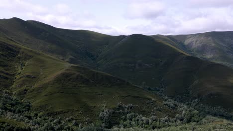 aerial drone footage overlooking a valley in a lush mountain range landscape
