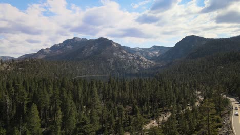 drone volando sobre un denso bosque y un lago en cascada en tahoe, california