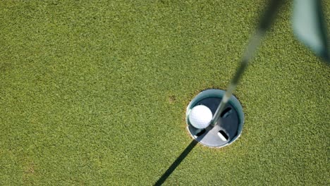 top down shot of golf ball falling into the hole