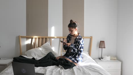 adolescente usando un teléfono inteligente en un dormitorio