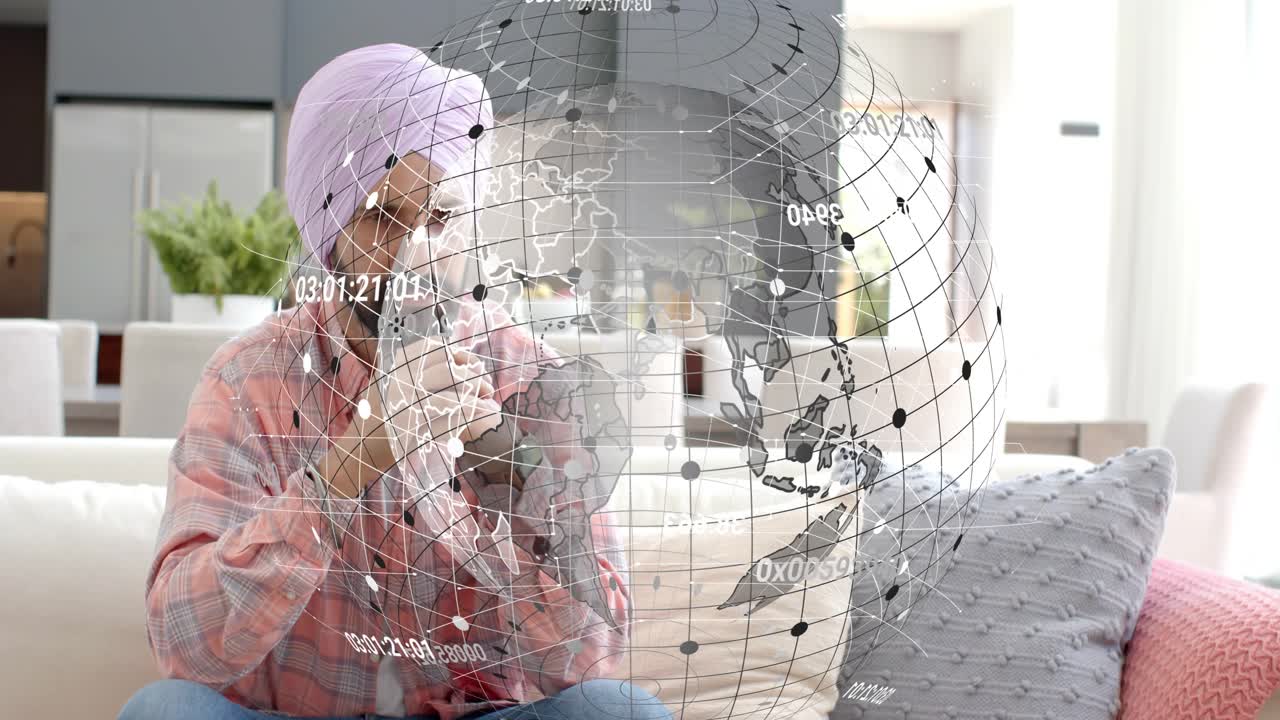 Man sitting on couch, following holographic globe appearing and rotating, analyzing tech data