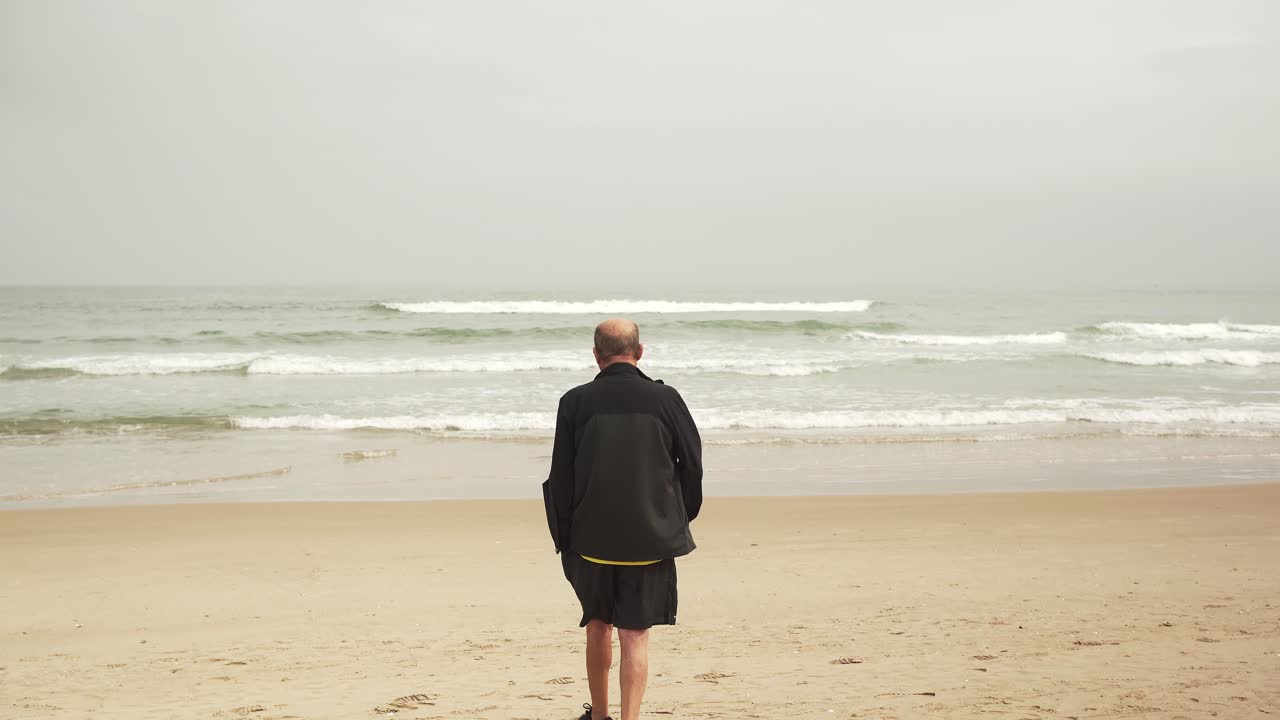 atleta masculino senior caminando cerca del mar