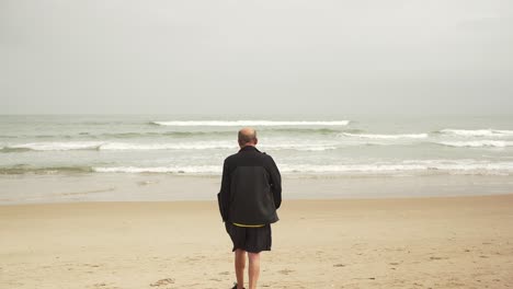 senior male athlete walking near sea