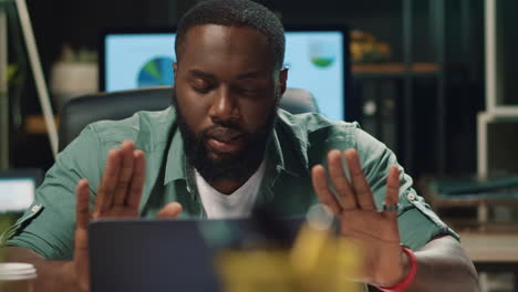 closeup afro hipster guy convincing colleague by video chat indoors