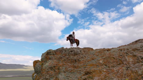 Mongolische-Adlerjäger-Jagen-Mit-Adlern,-Während-Sie-Zu-Pferd-Auf-Der-Klippe-In-Der-Westmongolei-Reiten