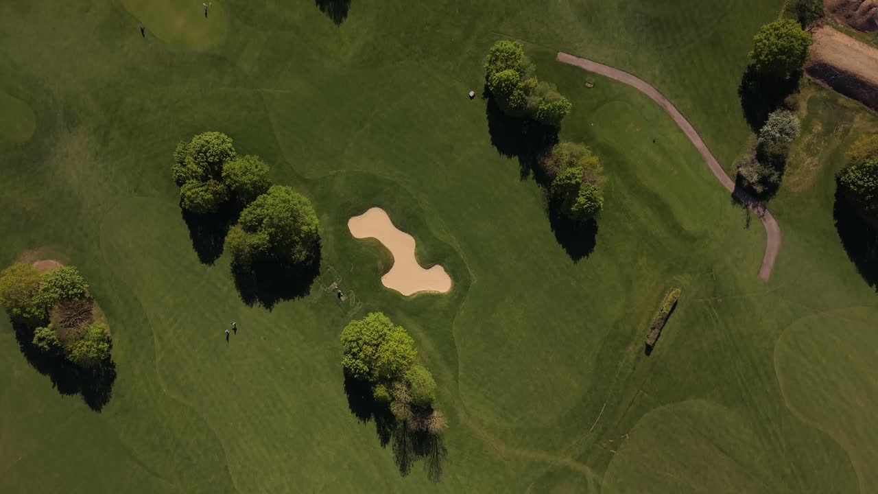 Vista aerea di un campo da golf verde con alberi e bunker di sabbia.