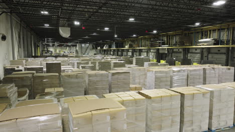 aerial ascending view of warehouse with pallets of boxes ready for shipment