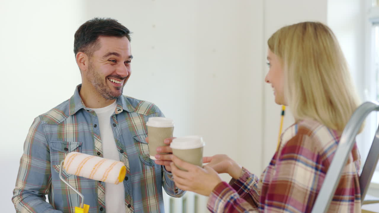Couple Having Coffee Break During Home Painting Project