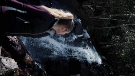 vertical shot of a woman near cascades of saint-come mountain hike in quebec, canada