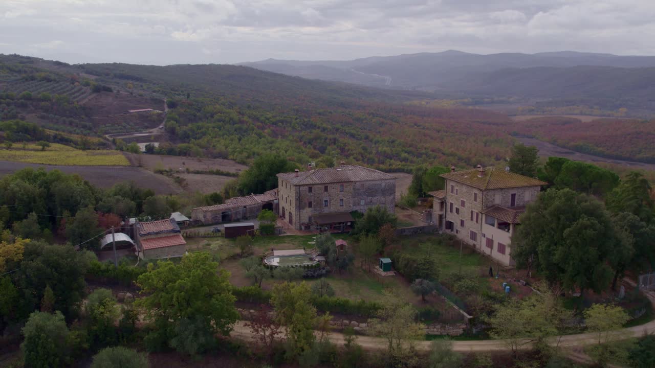 Veduta aerea di vigneti vivaci e colline boscose in autunno, Toscana, Italia
