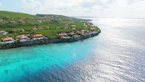 órbita aérea panorámica de impresionantes villas en los acantilados con vistas a aguas cristalinas y arrecifes de coral