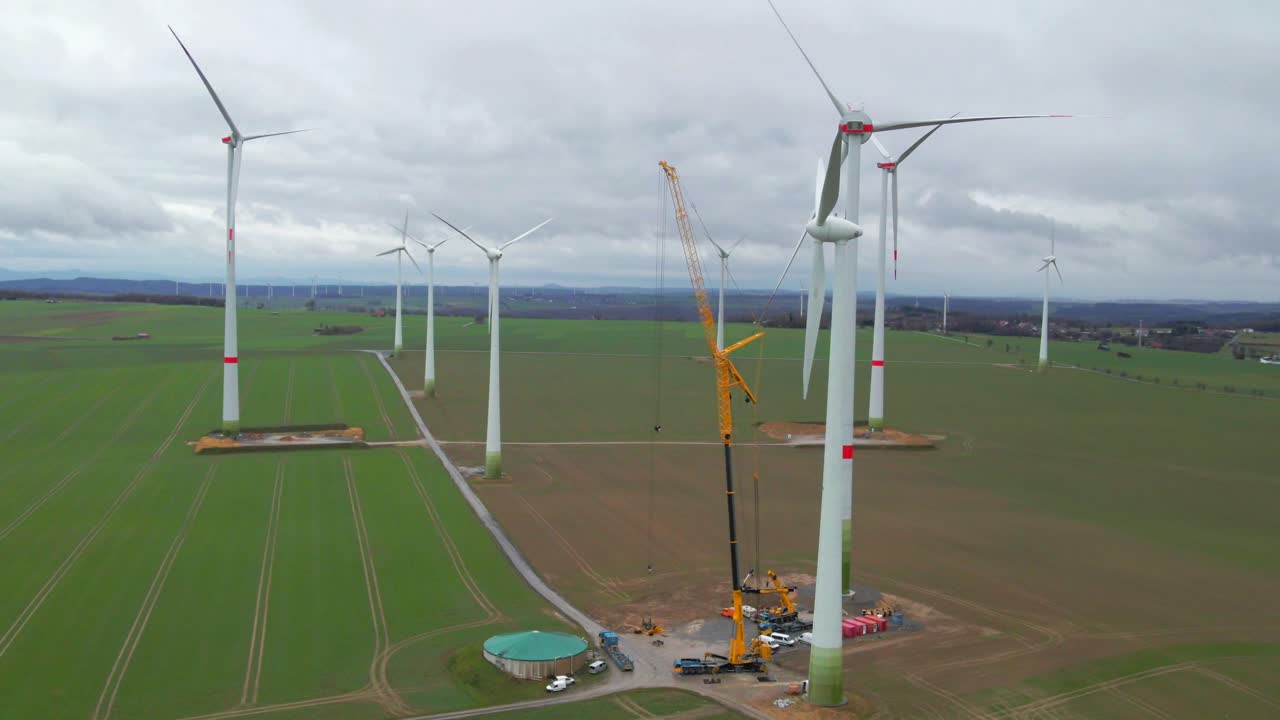 символ возобновляемой энергии: кран помогает в строительстве ветряной турбины в пасмурный день в бад вюнненберге, падерборн, северный рейн-вестфалия, германия