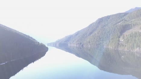 high key, ethereal panning mountain lake scene with lens flare